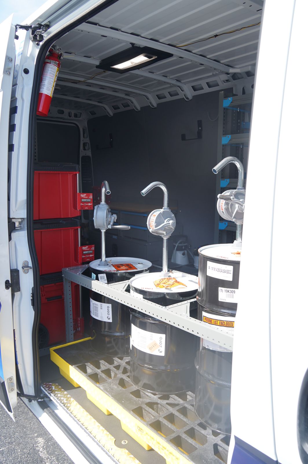 Bulk oil drums with pumps racked inside the mobile service van