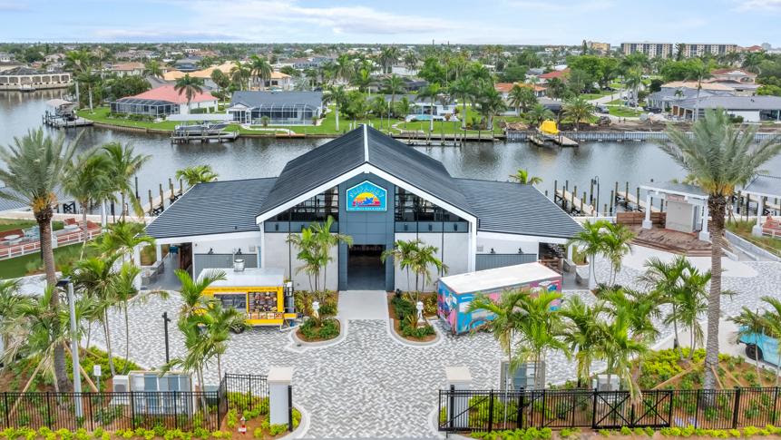 Aerial view of Slipaway Food Truck Park & Marina on the Caloosahatchee River in Cape Coral, Florida, with food trucks, waterfront seating and boat docks.